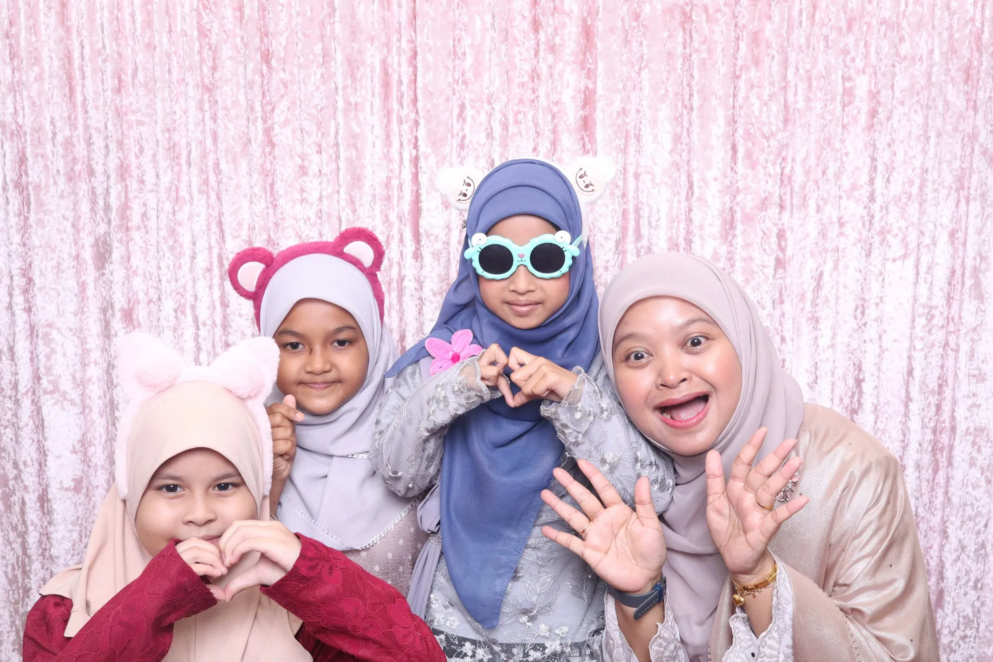 Aksi tetamu di depan backdrop photobooth pada rumah terbuka hari raya Raikan Bersama Kelab Rekreasi CIMB Malaysia di Ancasa Royale