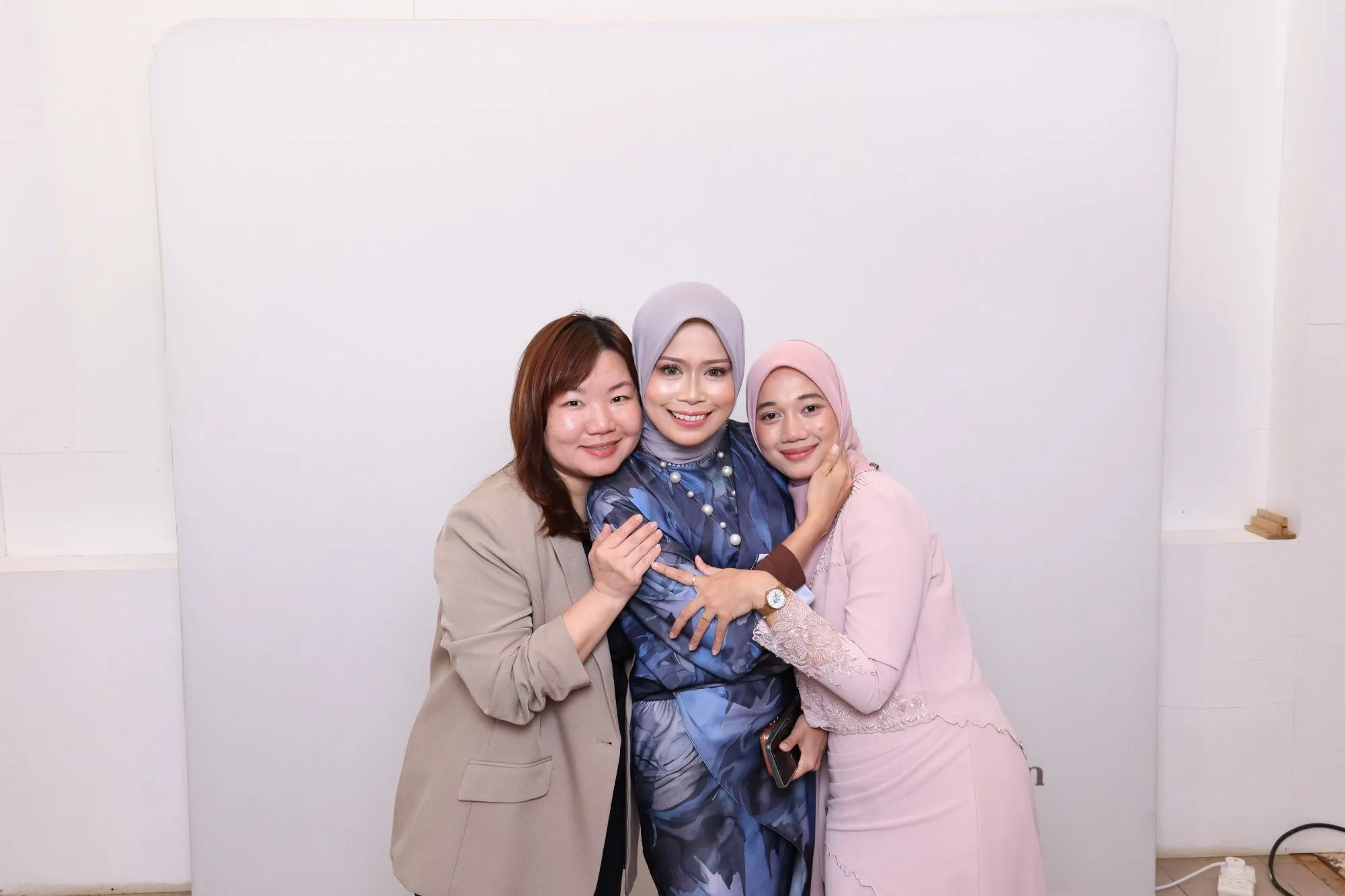 Aksi tetamu di depan backdrop photobooth pada rumah terbuka hari raya Sambutan Hari Raya bersama Lagenda Properties di Timorra Venue