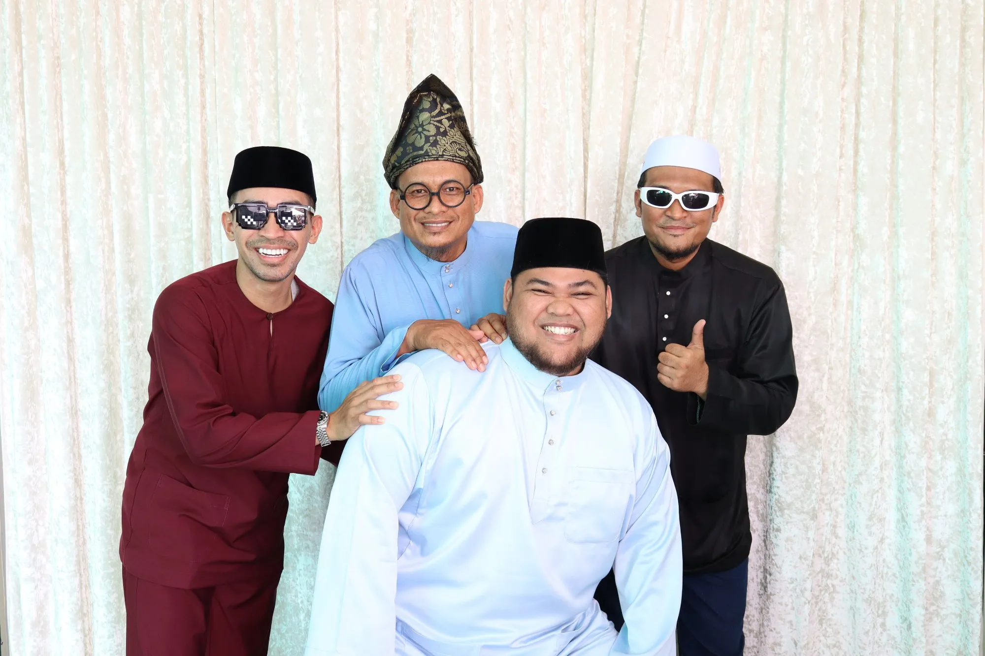 Aksi tetamu di depan backdrop photobooth pada rumah terbuka hari raya Hari Raya bersama Musolla Ar Raudah di Musolla Ar Raudah