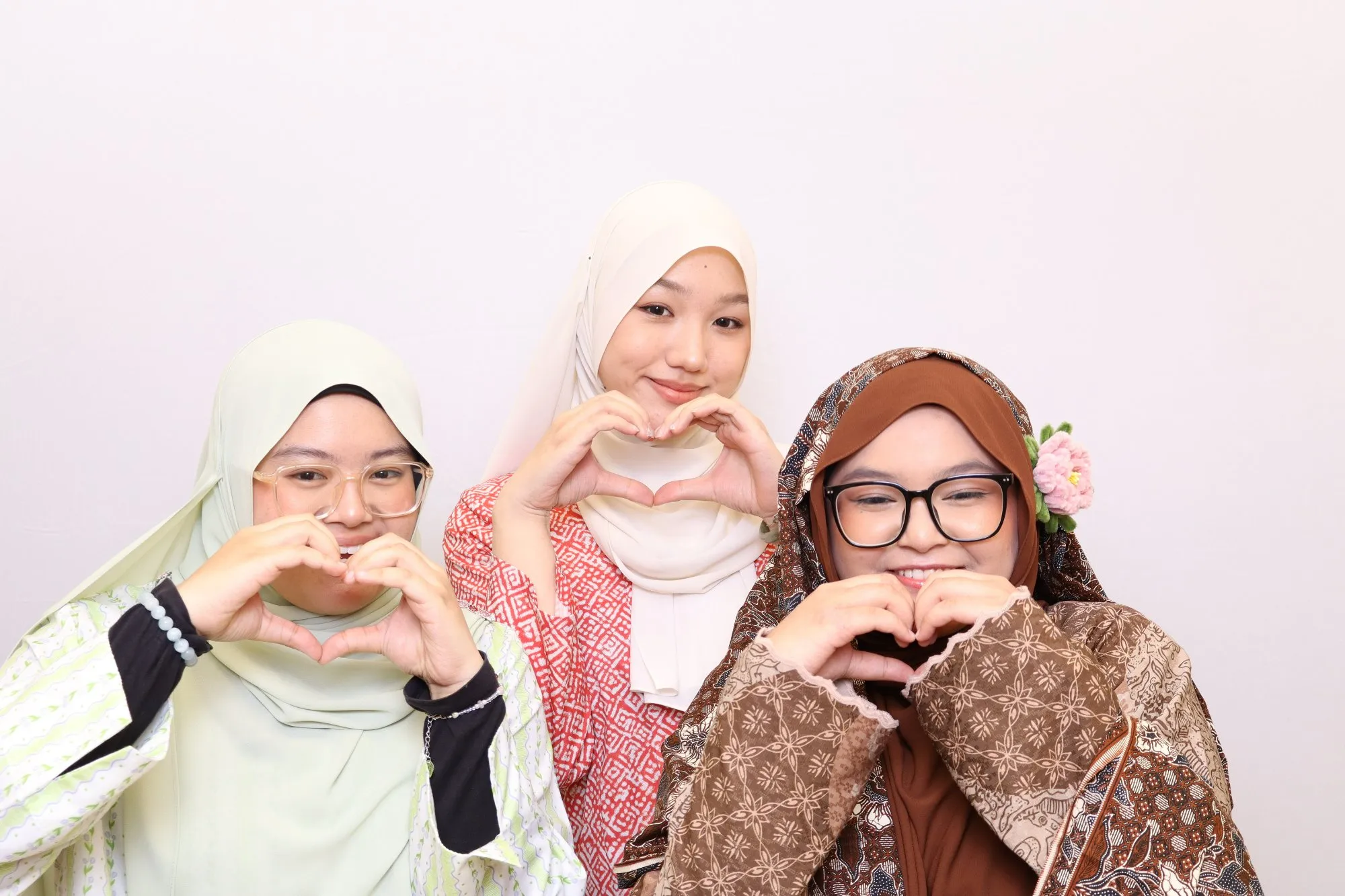 Aksi tetamu di depan backdrop photobooth pada makan malam pelajar Rona Nusantara: Malam Busana Sarong di IIUM Kulliyah of Medicine